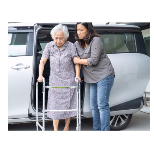A woman helping her mother who uses a walker out of the car.