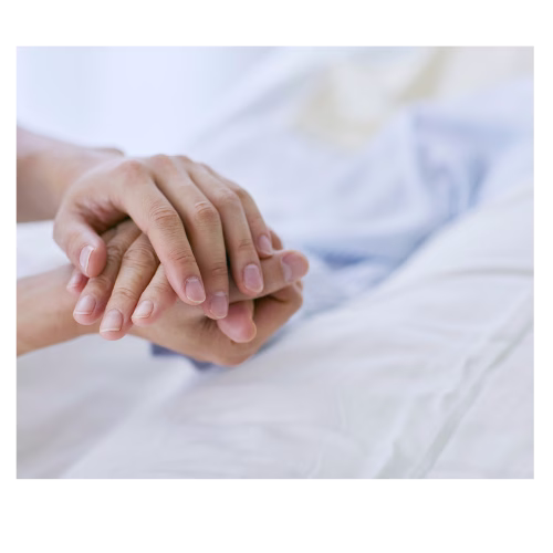 Patient led in a hospital bed with a visitor clasping their outstretched hand